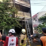 Petugas pemadam kebakaran melakukan penanganan pasca-kebakaran rumah di Matraman Jakarta Timur